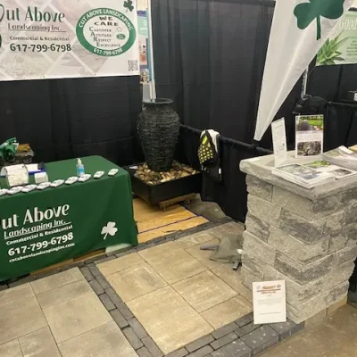 Cut Above Landscaping Inc. display booth with Unilock pavers, fountain, and promotional materials at a home show.
