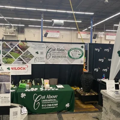 Cut Above Landscaping Inc. home show display with branded banners, promotional materials, and Unilock pavers.