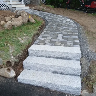 Unilock paver walkway and granite steps connecting driveway to front entrance.