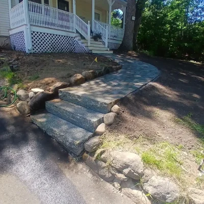 Unilock paver walkway and granite steps connecting driveway to front entrance.