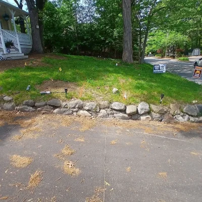Modified stone wall and prepared walkway base for Unilock paver installation.